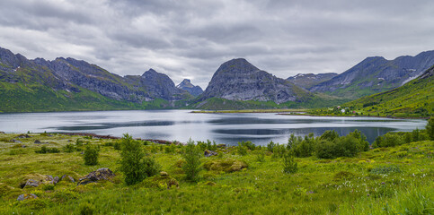 Fjord landscape under overcast sky on the Lofoten in northern Norway in panorama format