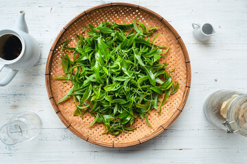 Fototapeta na wymiar Green tea leaves in a wooden tray