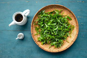 Green tea leaves in a wooden tray © artrachen