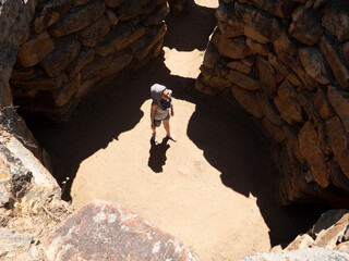young girl tourist whatches nuraghi in sardinia.  Young woman traveler in sardinia. Travel and...