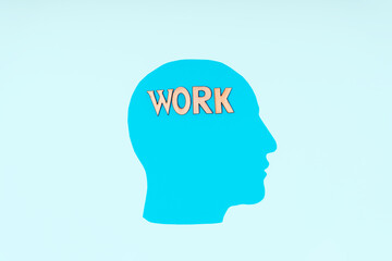 Paper blue head with wooden letters "work". The workaholic concept