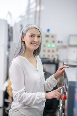 Contented woman near control panel of washing machine
