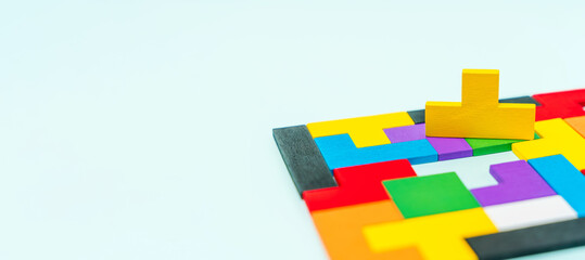 Geometric shapes made of wood in different colors on a blue background with a missing shape, background image with space for text