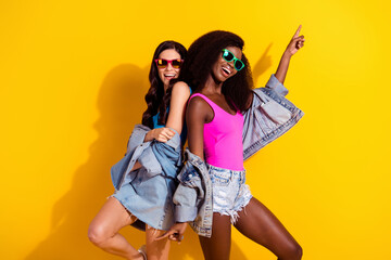 Profile photo of optimistic cool brunette hairdo ladies dance wear bright tops spectacles jeans shirts isolated on yellow color background