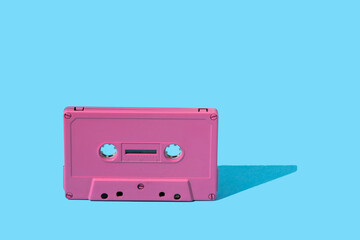 pink audio cassette on a blue background. stock photo