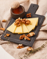 Cheese plate. Sliced cheese. Delicious sliced cheese and nuts