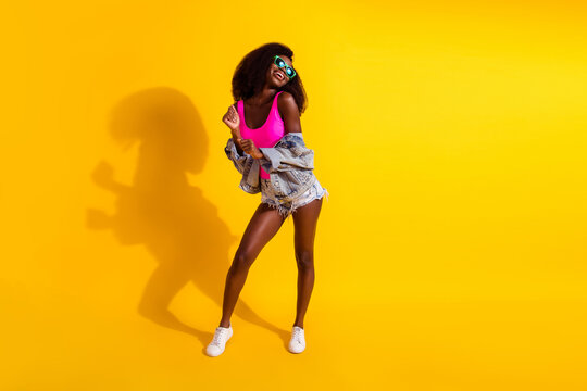 Full size photo of stunning afro american woman look empty space dance isolated on shine yellow color background