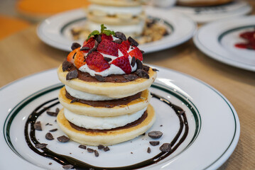 Chocolate pancake stack. Stacks of  pancake stuffed with fresh cream and chocolate, topped with strawberry.