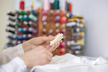 Obraz premium Female hands holding skein of beige threads