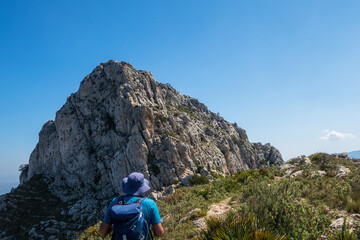 Fototapeta premium Hikers walking on mountains, in a sunny spring day. In La vall de laguar, Alicante (Spain)