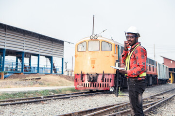 African engineer   control a the train on railway with talking by radio communication or walkie talkie