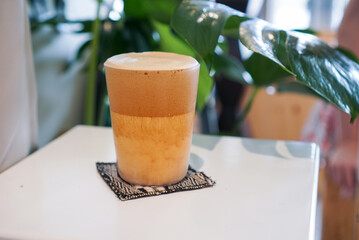 Iced cappuccino coffee. A mug of coffee, milk and coffee foam on white table.