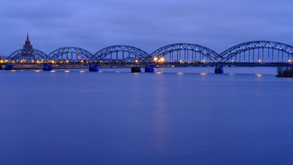 Cloudy morning, clouds over the Daugava in Riga, railway bridge in the lights