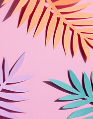 Paper tropical palm leaves on the pink background. Summer concept Top view	