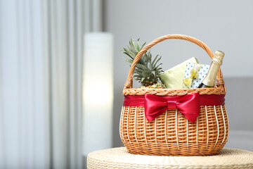 Fototapeta na wymiar Wicker basket full of gifts in living room. Space for text