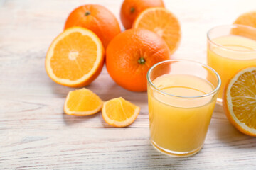 Delicious orange juice and fresh fruits on white wooden table. Space for text
