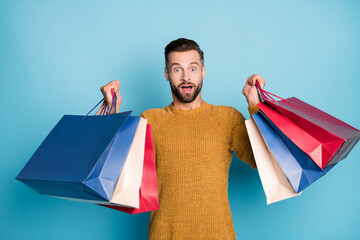 Photo of young happy excited amazed handsome man sees big sale disocunt isolated on blue color...