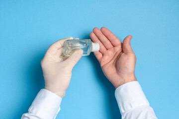 hand sanitizer treatment, health care prevention of coronavirus infection, hands in medical gloves on a blue background