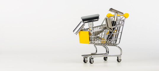 metallic safety razors in shopping cart isolated on white background 