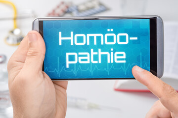 Smartphone mit dem Text Homöopathie auf dem Display