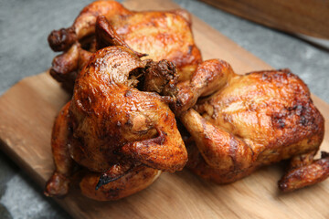 Delicious grilled whole chickens on grey table, closeup