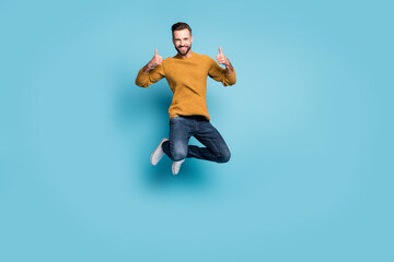 Fototapeta na wymiar Full length body size view of nice cheerful guy jumping showing double thumbup advert isolated on bright blue color background