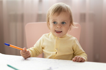 Baby draws at the table