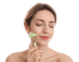 Young woman using natural jade face roller on white background