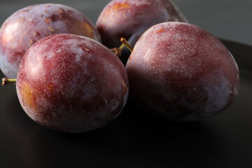 fresh plums in a black plate