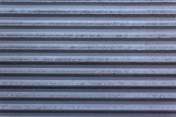 Corrugated sheet metal, badly painted with gray paint for background. Metal corrugated roofing sheet.Painting of metal surfaces for rust control Abstract background for sites and layouts. Iron fence