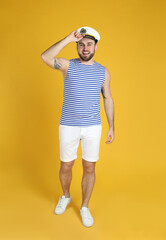 Full length portrait of sailor on yellow background