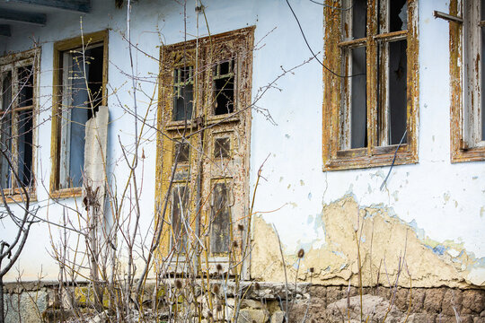 Facade Of Abandoned House. Old Wooden Door. Old Wall With Big Vintage Gates