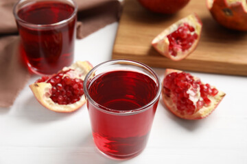 Freshly made pomegranate juice on white wooden table
