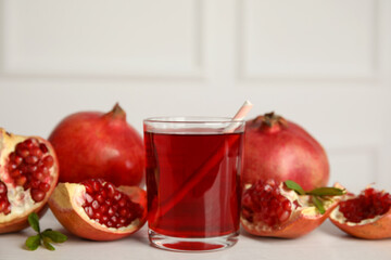 Glass of pomegranate juice and fresh fruits on white table