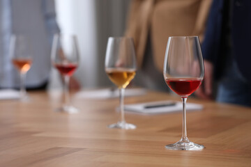 Sommeliers making notes during wine tasting at table indoors, closeup