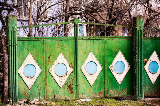 Facade Of Abandoned House. Old Wooden Door. Old Wall With Big Vintage Gates