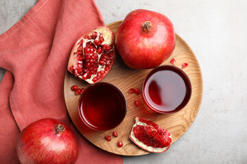 Pomegranate juice and fresh fruits on grey table, flat lay