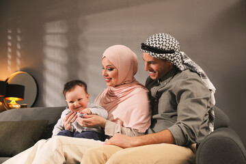 Obraz premium Happy Muslim family with little son in living room