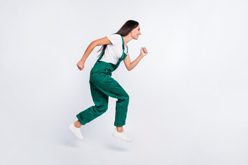 Profile photo of positive cute lady jump run look empty space wear green overall shoes isolated white color background
