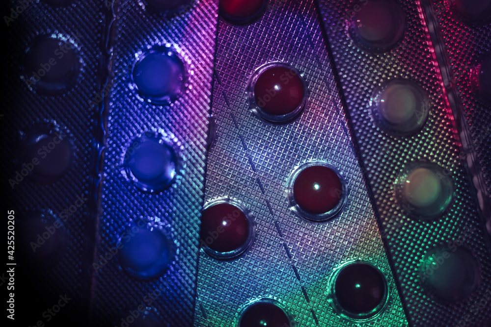 Poster pills or drugs in a package under neon light on a dark background pattern for design..