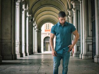 Fototapeta premium Handsome muscular blond man standing in city setting
