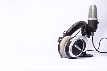 home work, professional condenser microphone and headphones on white background, high key portrait,...