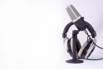 home work, professional condenser microphone and headphones on white background, high key portrait,...