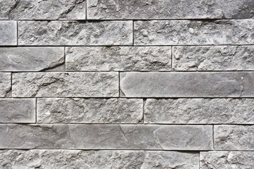 Gray house facade background. Gray brick wall texture. Decorative stone blocks structure. Grunge architecture pattern. Retro tile backdrop. Modern rock background.