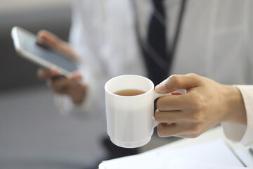 Businessman drinking coffee with smartphone 