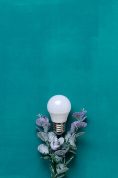 Vertical image of matt bilb and green foliage on the blue surface.Blank space