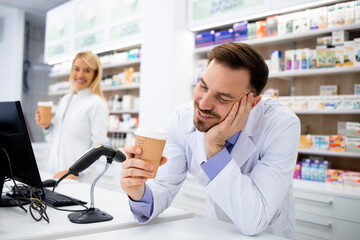 Pharmacist enjoying cup of coffee at work in drug store.
