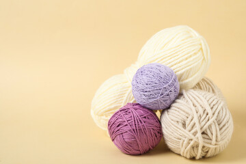 Soft colorful woolen yarns on beige background. Space for text