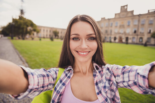 Photo of charming beautiful young student girl make camera selfie positive smile outside in university outdoors