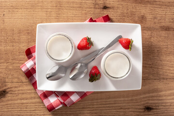 Panna cotta dessert with strawberry on wooden table.Top view. 